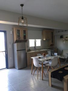 a kitchen with a table and chairs and a refrigerator at La casa di Elen in Plati