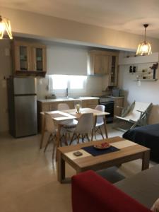 a living room with a table and a kitchen at La casa di Elen in Platy