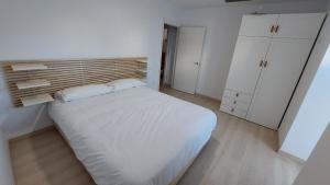 Dormitorio pequeño con cama blanca y armarios blancos en A Casa da Compañía, en Monforte de Lemos