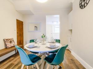 a dining room with a white table and blue chairs at To Be in Scarborough