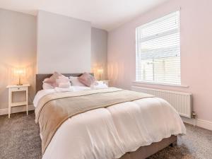 a bedroom with a large white bed with a window at To Be in Scarborough