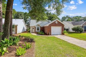 a brick house with a garage in a yard at Sunrunner Cottage in Pensacola