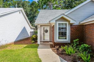a brick house with a white door and a sidewalk at Sunrunner Cottage in Pensacola