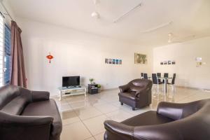 a living room with two leather chairs and a television at COCONUT HOMESTAY Tanjong Karang Sekinchan Kuala Selangor in Kampong Sungai Kajang