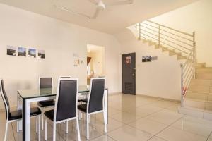 a dining room with a table and chairs and stairs at COCONUT HOMESTAY Tanjong Karang Sekinchan Kuala Selangor in Kampong Sungai Kajang