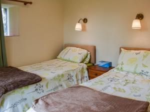 a bedroom with two beds and a dresser and two lamps at Cherry Barn in Dufton