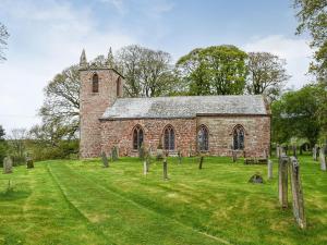 an old brick church with cemeteries in the grass at Cherry Barn in Dufton