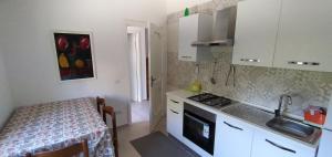 a kitchen with a sink and a stove and a table at VILLA VERDEMARE in Paestum