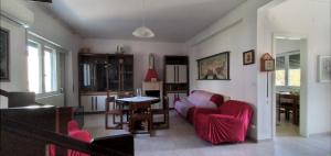 sala de estar con sofá rojo y mesa en VILLA VERDEMARE en Paestum