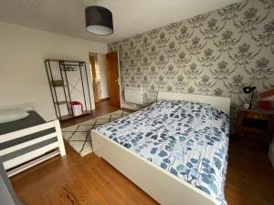 ein Schlafzimmer mit einem Bett mit einer blau-weißen Bettdecke in der Unterkunft Les Limicoles maison proche mer in Gouville-sur-Mer + 16 Fotos