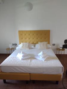 Una cama grande con sábanas blancas y toallas. en Lugh'e Luna Village, en Narbolia