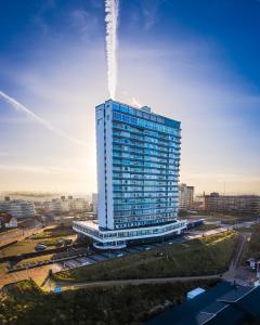 ein hohes Gebäude in einer Stadt mit einem Himmel in der Unterkunft Palace Hotel Zandvoort in Zandvoort