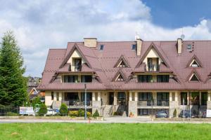 a large house with a red roof at Villa Broniewskiego in Zakopane