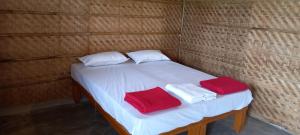 Dusk Till Dawn في هامبي: سرير صغير عليه مناشف حمراء وبيضاء