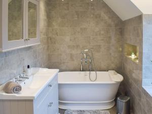 a bathroom with a white tub and a sink at Tennox House - Uk36254 in Kilbirnie