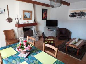 a living room with a table and a fireplace at Ty Kreiz in Saint-Ségal