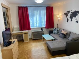 a living room with a couch and a tv at AJO Vienna Atos with free parking in Vienna