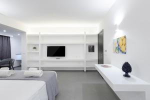 a white room with a bed and a tv at Suite Palermo Apartment in Palermo
