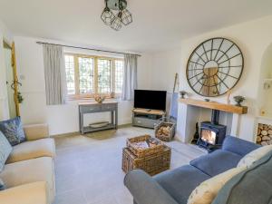 a living room with a couch and a fireplace at Blossom Cottage in Broadway