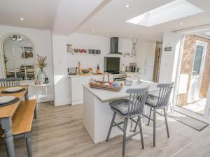 a kitchen and dining room with a table and chairs at Blossom Cottage in Broadway
