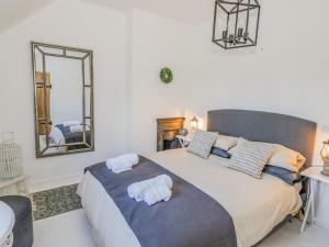 a bedroom with a large bed with towels on it at Blossom Cottage in Broadway