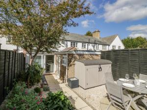 a garden with a table and a fence at Blossom Cottage in Broadway