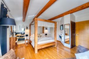 a bedroom with a canopy bed and a desk at Mas des Cigales in Eygalières