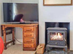 TV con escritorio y chimenea en Pear Tree Cottage, en Bath