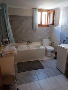 a bathroom with a tub and a toilet at Anna's Home in Ermoupoli