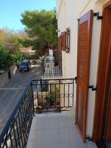una porta aperta su un balcone con auto di Anna's Home a Ermoupoli