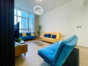 Una sala de estar con un sofá azul y una mesa. en Elite Private Residential Apartment in a Prime Location Al Reem Island - 1301, en Abu Dabi