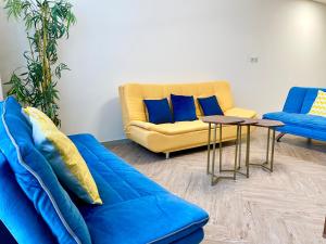 ein Wohnzimmer mit einem blauen Sofa und einem Tisch in der Unterkunft Elite Private Residential Apartment in a Prime Location Al Reem Island - 1301 in Abu Dhabi