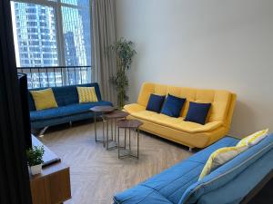 a living room with a yellow couch and blue pillows at Elite Private Residential Apartment in a Prime Location Al Reem Island - 1301 in Abu Dhabi