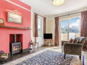 a living room with a fireplace and a red wall at Cavern House in Torquay