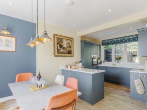 a kitchen with blue cabinets and a table with orange chairs at Cavern House in Torquay
