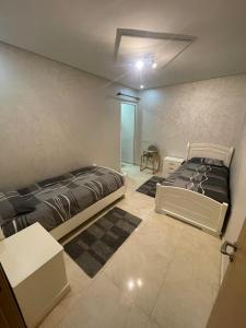 Habitación con 2 camas y mesa. en Apartment Anis Nador Al Jadid en Nador