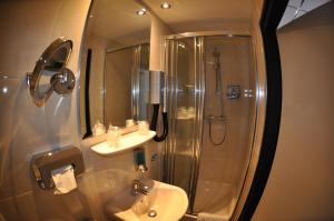 a bathroom with a shower and a sink and a toilet at Hotel Le Beau Rivage in Middelburg +43 photos