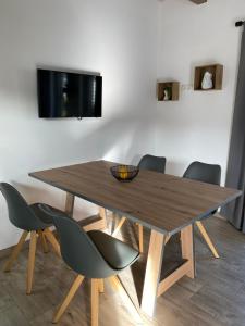 uma mesa de madeira com cadeiras e uma televisão na parede em Fichtelcube de em Schönwald