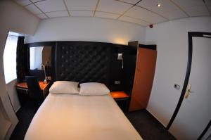 een slaapkamer met een groot bed met een zwart hoofdeinde bij Hotel Le Beau Rivage in Middelburg