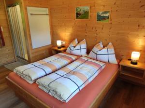 a bedroom with a bed in a wooden cabin at Ferienwohnungen Schneiderhäusl in Alpbach