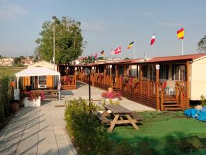 a deck with a picnic table and flags of countries at VILLAGGIO degli ANGELI SCERNE PINETO in Scerne