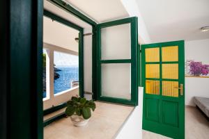a room with a green door and a window at The Captain's Nook Spiliska in Blato