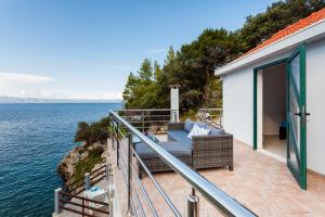 einen Balkon eines Hauses mit Blick auf das Wasser in der Unterkunft The Captain's Nook Spiliska in Blato