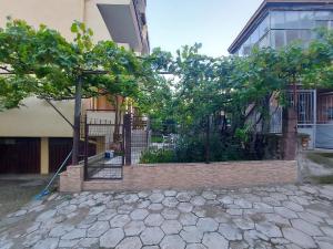 a fence with trees in front of a building at White grapes apartment in Petrich