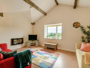 a living room with a couch and a tv at Courtyard Cottage - Uk39179 in Rossendale