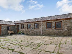 een stenen huis met een bank ervoor bij Courtyard Cottage - Uk39179 in Rossendale