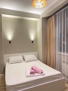 Un dormitorio con una cama con toallas rosas. en ЖК Ламия en Almaty