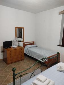 1 dormitorio con 2 camas y vestidor con espejo en Casa di Stefano, en Villamassargia