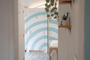 a bathroom with a blue and white striped wall at GARDEN - Utopy Hostel in Biarritz