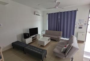 a living room with a couch and a tv at Desaru Happy Guest House D in Desaru